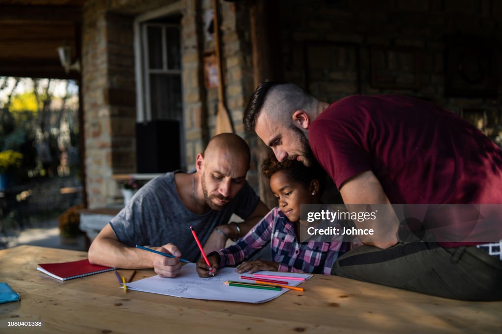 Gay couple spending creative time with their daughter