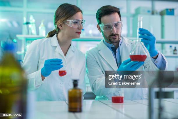 giovani studenti che collaborano mentre lavorano in laboratorio. - becher foto e immagini stock