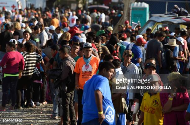 Central American migrants, taking part in a caravan heading to the US, queue to receive a meal at a temporary shelter in Irapuato, Guanajuato state,...