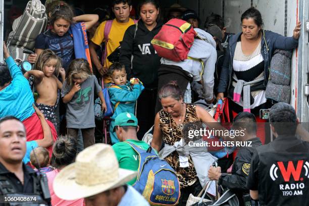 Central American migrants moving in a caravan towards the United States, descend from a truck to be taken to a shelter, in the outskirts of...