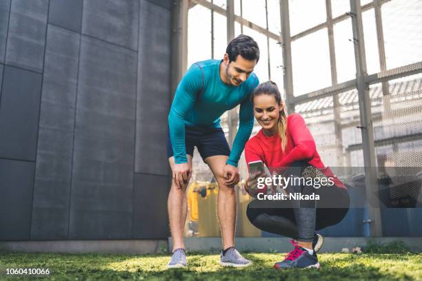 couple checking at their workout performance on phone app - sport performance stock pictures, royalty-free photos & images