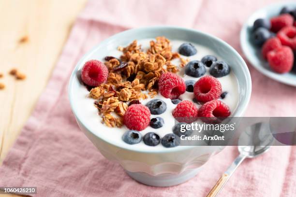 yogurt with granola and berries in bowl - yogurt parfait stock pictures, royalty-free photos & images