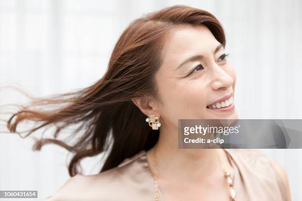 smiling middle aged woman - hair clip - fotografias e filmes do acervo