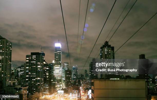 view from aerial tramway along the queensboro bridge connecting manhattan and roosevelt island. new york city, usa - photopollution stock-fotos und bilder