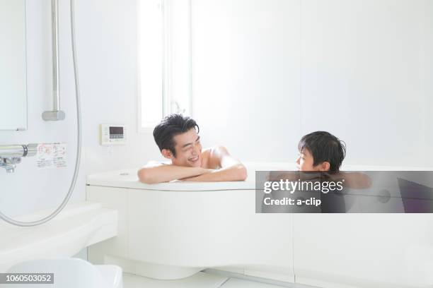 father and son taking a bath - taking a bath stock-fotos und bilder