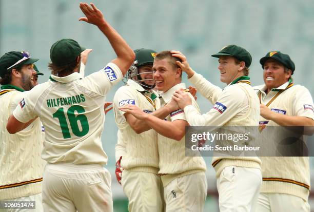 Xavier Doherty of the Tigers is congratulated by his team mates after dismissing Chris Rogers of the Bushrangers during the Sheffield Shield match...