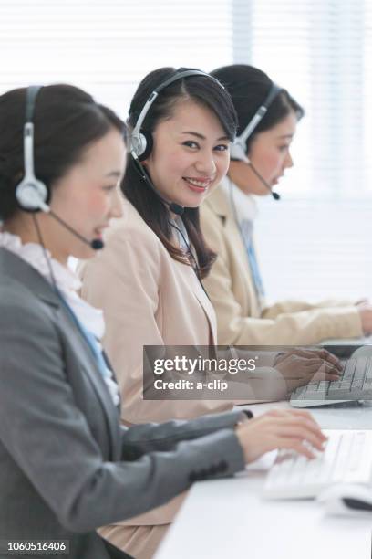 インカムで話をしながらpcを使う女性オペレーター - コールセンター　日本 ストックフォトと画像