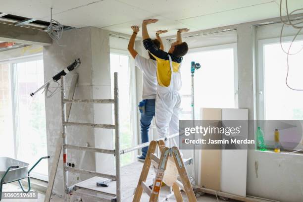 man working on drywall - plaquiste photos et images de collection