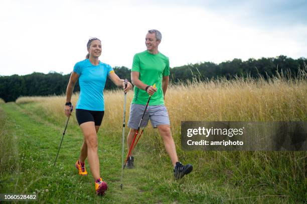 personal nordic walking instructor with female customer - nordic walking stock pictures, royalty-free photos & images