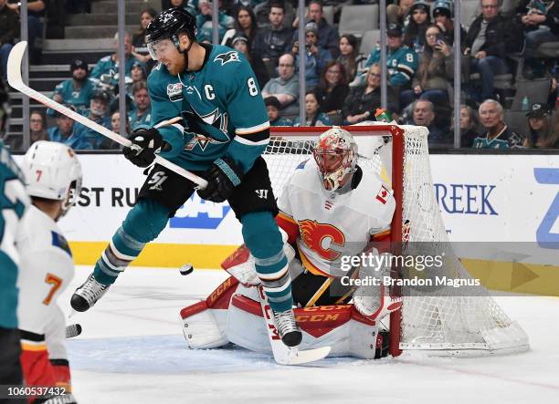 Joe Pavelski of the San Jose Sharks and Mike Smith of the Calgary Flames battle in front of the goal at SAP Center on November 11, 2018 in San Jose,...