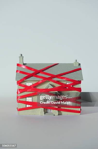 house wrapped in red tape. - bureaucracy stock pictures, royalty-free photos & images