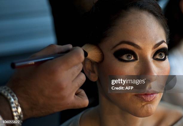 Model gets her make up done backstage for presentations by Mexican designer Edgardo Luengas during the Mercedes Benz Fashion Week in Mexico City on...