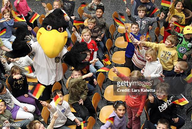 Pupils pose with the Mascot during a visit of the Women National Team of Germany at the Hans-Andersen-School on October 26, 2010 in Wolfsburg,...
