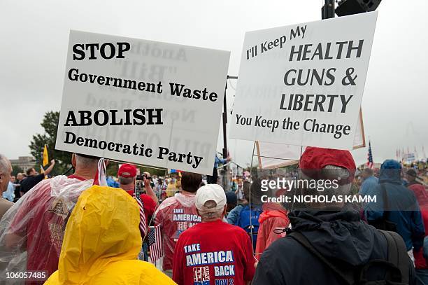 Demonstrators carry signs against the administartion of US President Barack Obama during a march by supporters of the conservative Tea Party movement...
