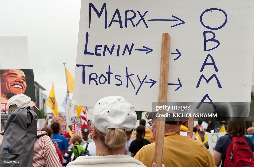 A demonstrator carries a sign equating U
