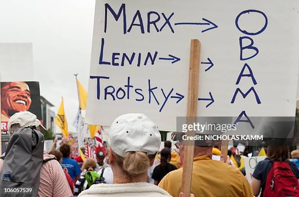 Demonstrator carries a sign equating US President Barack Obama to historical communist politicians Karl Marx, Vladimir Lenin and Leon Trotsky during...