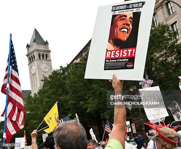 Demonstrator carries a sign calling people to "resist" US President Barack Obama perceived socialist policies during a march of supporters of the...