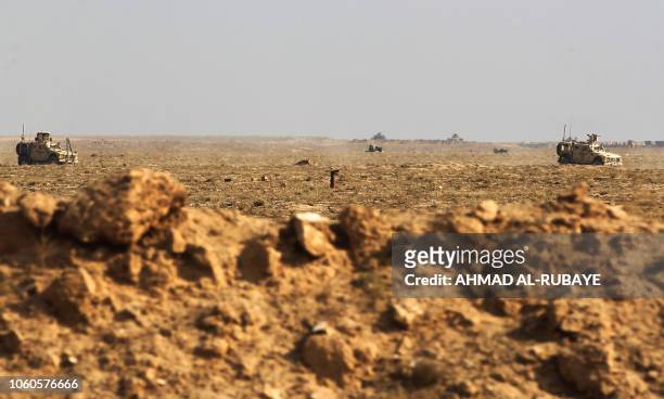 Picture taken near the Iraqi city of Qaim at the Iraqi-Syrian border on November 11 shows US Army vehicles patrolling the Syrian side of the border....