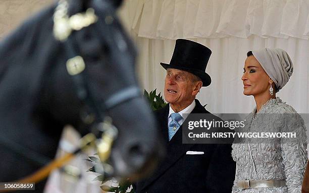 Britain's Prince Philip, stands with Sheikha Mozah, the wife of Qatar's emir, Sheikh Hamad bin Khalifa al-Thani, during a Ceremonial Welcome in their...