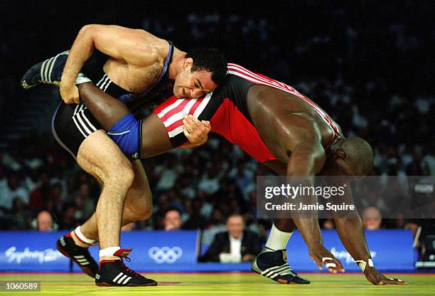 Alexis Rodriguez of Cuba is held by Krassimir Kotchev of Bulgaria during the 130 kilogram Freestyle wrestling event held at the Sydney Convention and...