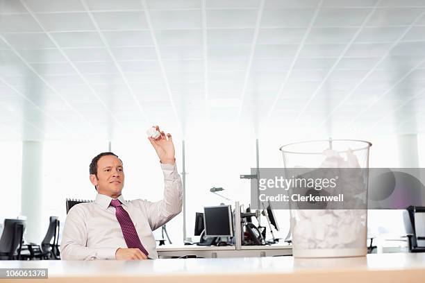 businessman tossing crumpled paper at waste bin - throwing paper stock pictures, royalty-free photos & images