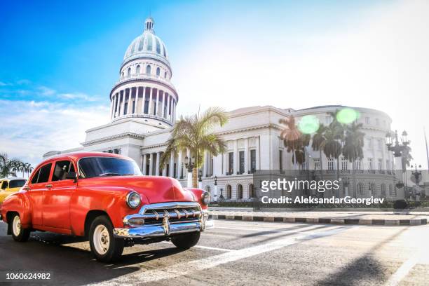 red authentic vintage car moving in front of el capitolio - cubano imagens e fotografias de stock