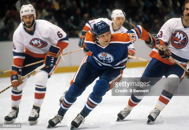 Dave Semenko of the Edmonton Oilers skates on the ice as Ken Morrow and Bob Nystrom of the New York Islanders follow during the Quarter-Finals in...