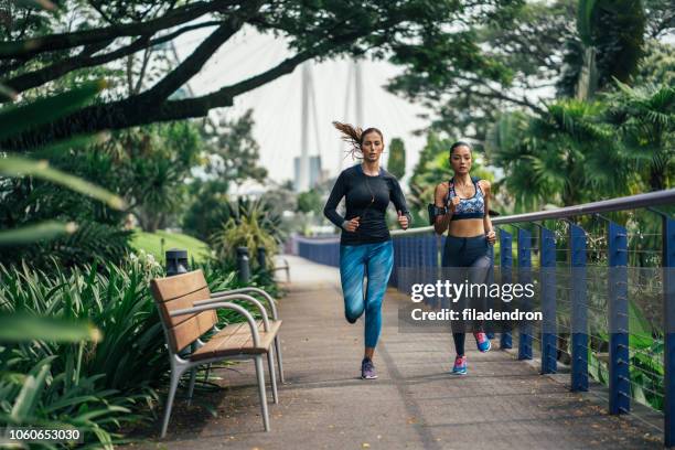 girlfriends running together - sprinting stock pictures, royalty-free photos & images