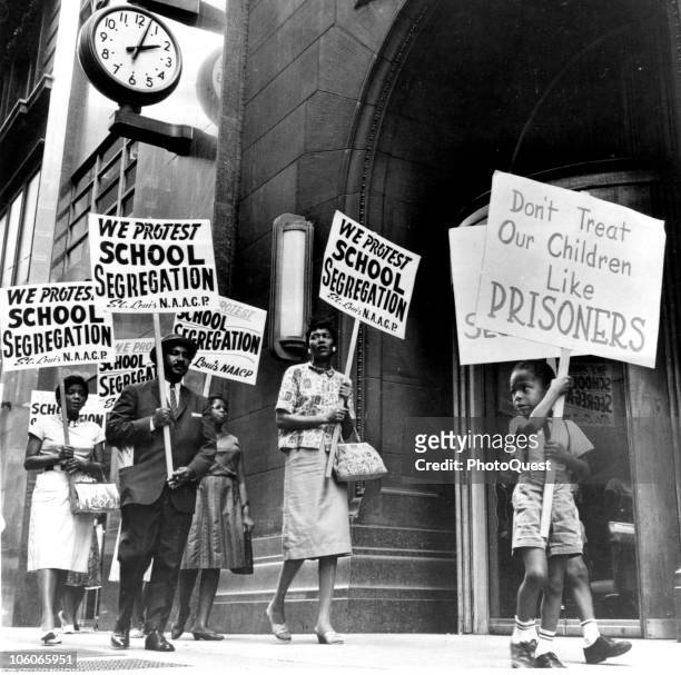 Demonstrators, a young boy among them, picket in front of a school board office in protest of segregation, St Louis, Missouri, early 1960s.