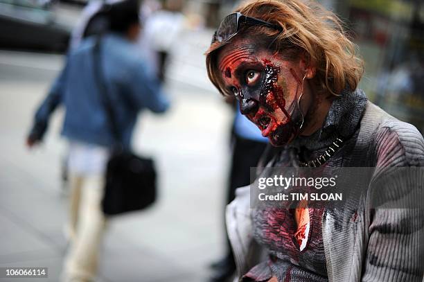 An actress portraying a zombie lurks on a city side walk to promote the new TV series "The Walking Dead" on the AMC channel on October 26, 2010...