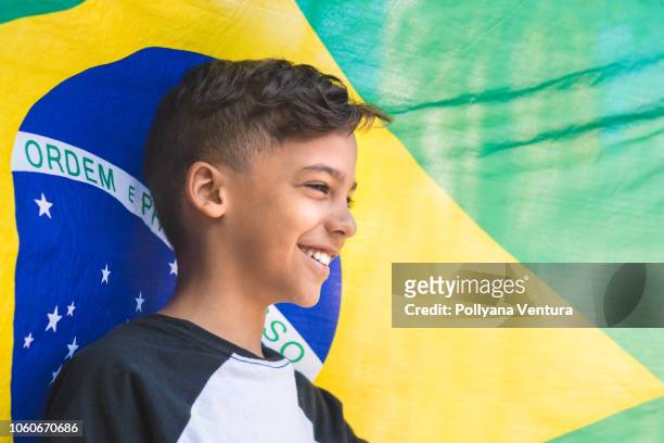 bambino contro la bandiera del brasile - brazilian flag foto e immagini stock