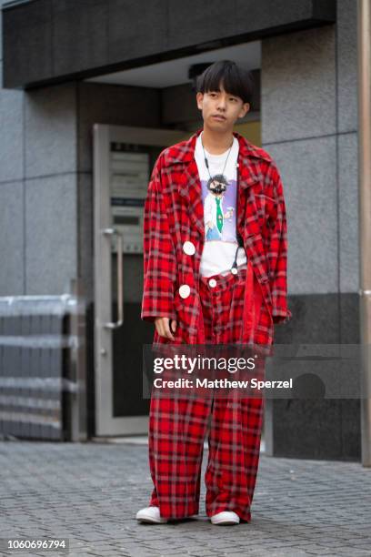 Local is seen on the street in Harajuku wearing red plaid outfit with graphic shirt and suspenders on October 26, 2018 in Tokyo, Japan.