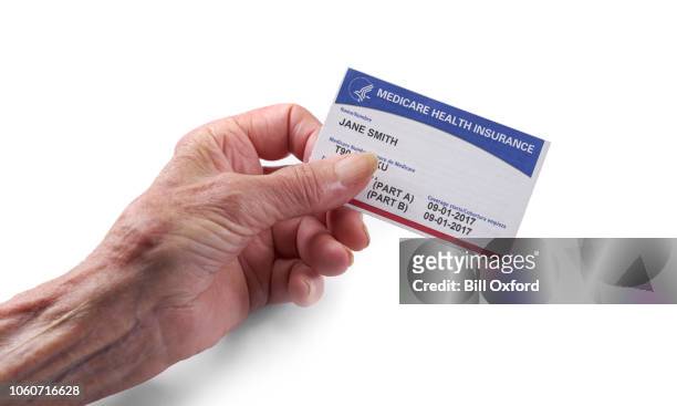 medicare sjukförsäkringskortet: kvinna som håller nya kort med vit bakgrund i hand - id cards bildbanksfoton och bilder