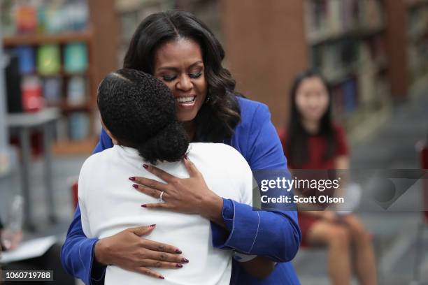 Former first lady Michelle Obama receives a hug from a student as she meets with 20 high school senior girls at Whitney Young Magnet School on...