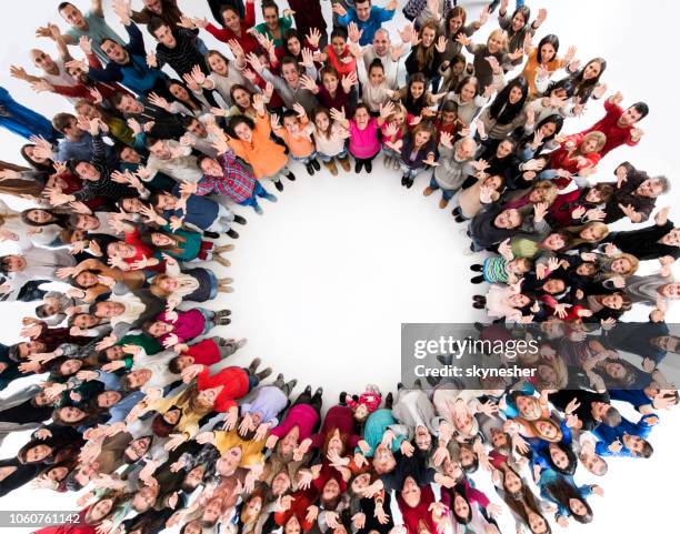 above view of crowd of people standing in circle with their hand raised. - large group of people from above stock pictures, royalty-free photos & images