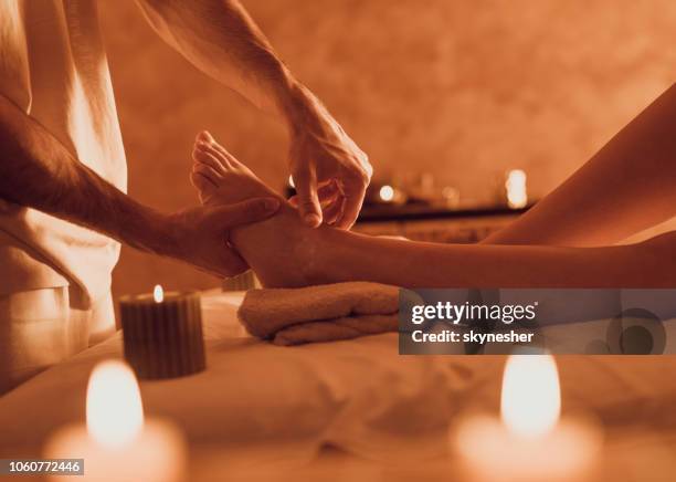 unrecognizable therapist massaging customer's foot at health spa. - reflexology stock pictures, royalty-free photos & images