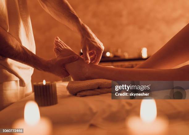 unrecognizable therapist massaging customer's foot at health spa. - foot spa stock pictures, royalty-free photos & images