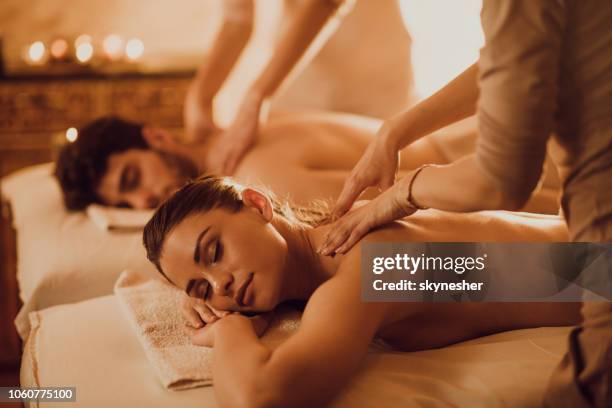 jong koppel met ontspannende rug massage in de spa van de schoonheid. - healing hands stockfoto's en -beelden