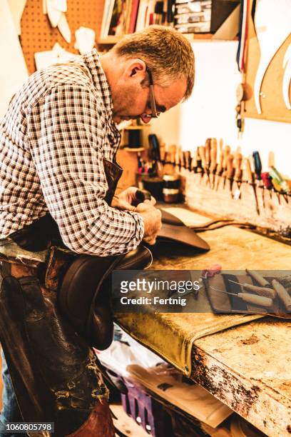 a saddle maker making a custom made saddle.  real person, real life. - saddler stock pictures, royalty-free photos & images