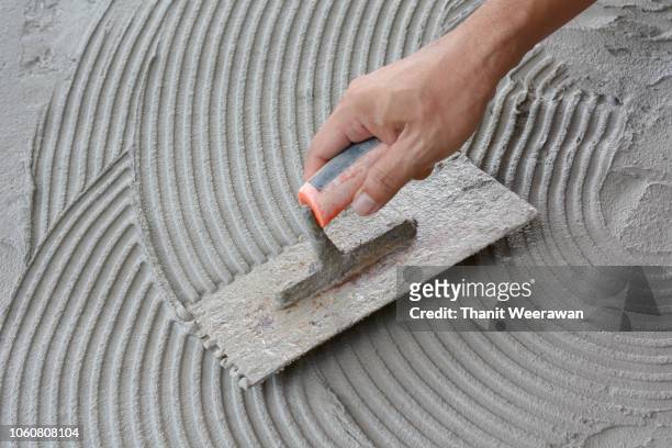 hand on be bound with cement , do cement work, apply cement (over a surface) - brick layer stock-fotos und bilder