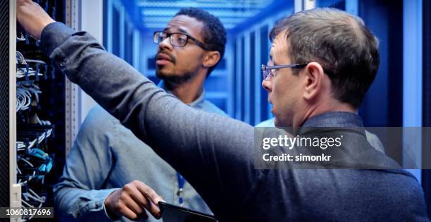 it engineers checking servers in server room - network engineer stock pictures, royalty-free photos & images