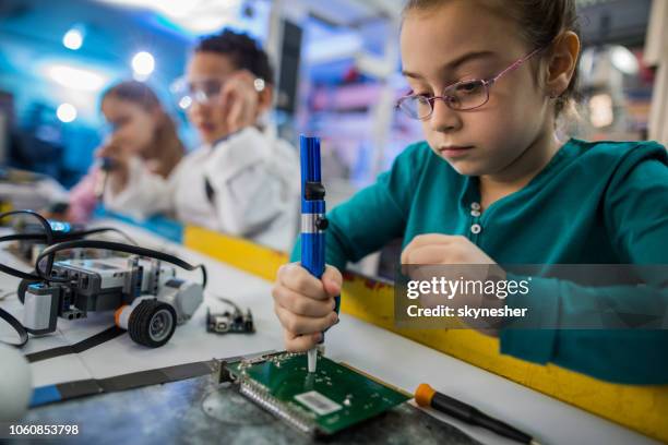 kleines mädchen auf motherboard im labor arbeiten. - lötkolben stock-fotos und bilder