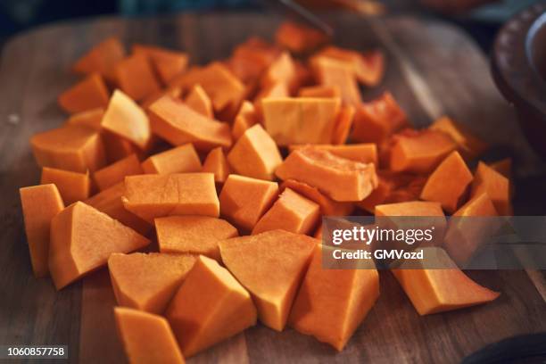 cutting fresh pumpkins on cutting board - hokaido pumpkin stock pictures, royalty-free photos & images