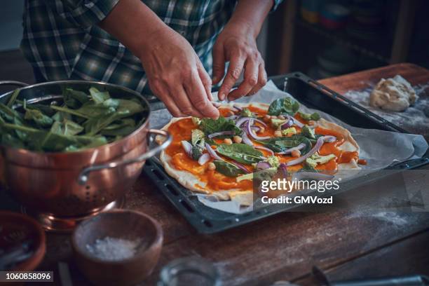 preparing vegan pumpkin pizza with broccoli, chickpeas and spinach - homemade stock pictures, royalty-free photos & images