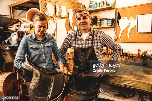 a saddle maker making a custom made saddle.  real person, real life. - leather craft stock pictures, royalty-free photos & images