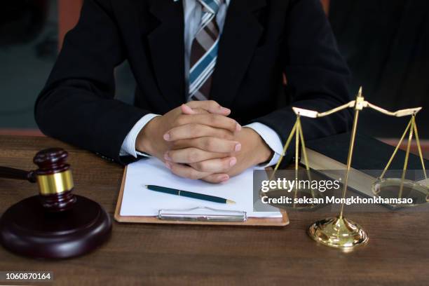 justice and law concept.male lawyer in the office with brass scale on wooden table,reflected view - criminal lawyer stock pictures, royalty-free photos & images