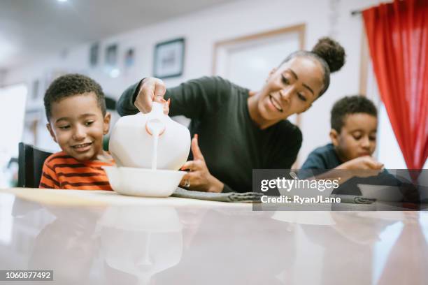 mother eating breakfast with her two boys - family milk stock pictures, royalty-free photos & images