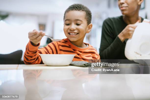 happy boy che mangia cereali per la colazione - boy eating cereal foto e immagini stock