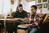 Father Teaches Child To Play Hand Drum