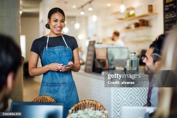 beautiful waitress  at cafe taking order from customers - waitress stock pictures, royalty-free photos & images